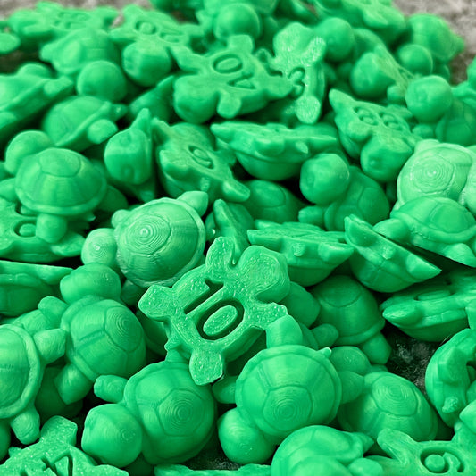 Close-up of many small green numbered turtles piled together showing shell and number details