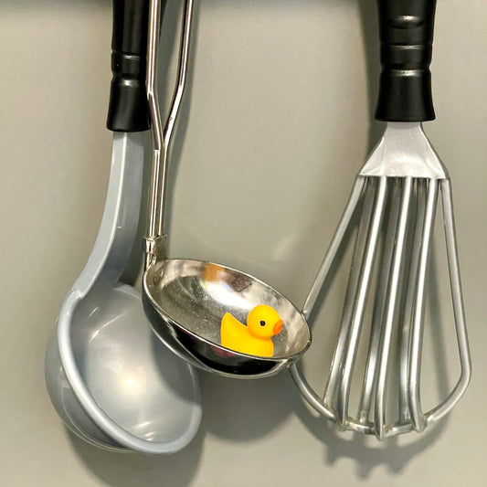 Tiny yellow numbered hunt duck hidden inside a kitchen ladle